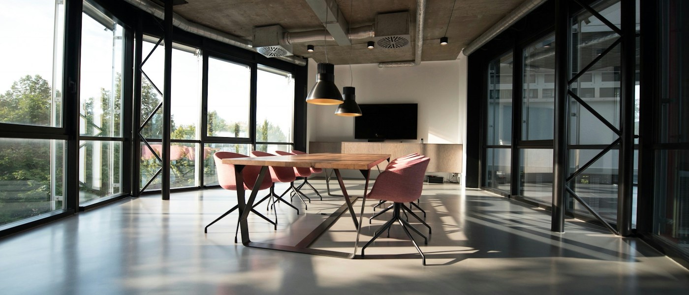 Open collaborative workspace with shared tables, natural light, and connected working areas